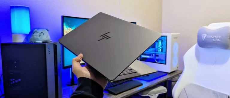 Hand holding a sleek HP laptop with the iconic logo on the lid, available at YourShoppy.com in Koramangala, Bangalore.