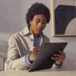 A young man using a Space Black Apple iPad Pro 13-inch M5 2TB Wi-Fi tablet with a stylus at YourShoppy.com in Koramangala.