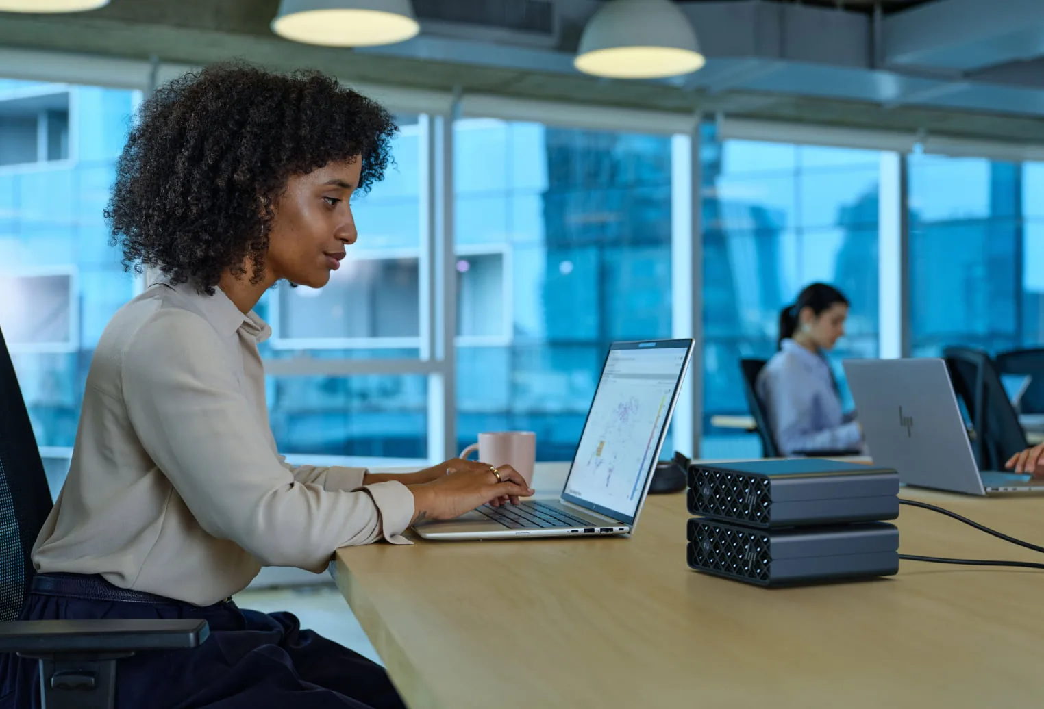 Developer using a laptop with HP ZGX Nano AI Stations on the desk